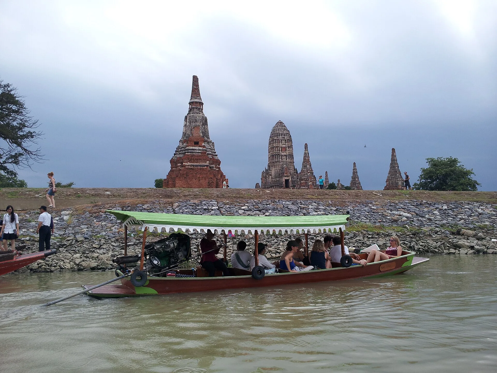 Longtail boat passing the Khmer-style prangs of Wat Chaiwatthanaram beside the river in Ayutthaya