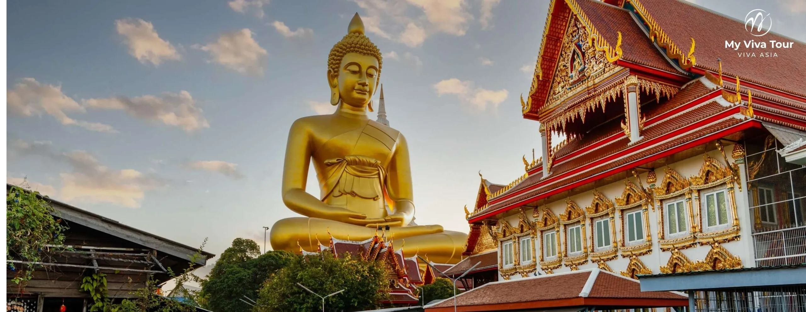Large golden seated Buddha beside an ornate red-and-gold temple in Chiang Rai