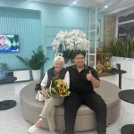 Vietnam dental travel — Karen Rooke with her My Viva Tour consultant and a sunflower bouquet