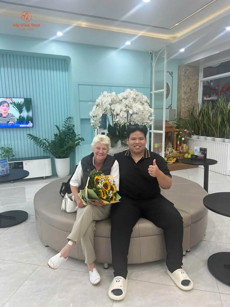 Vietnam dental travel — Karen Rooke with her My Viva Tour consultant and a sunflower bouquet