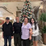 Mrs. Kim Cuc family Vietnam trip — four family members by a Christmas tree in a Hanoi hotel lobby