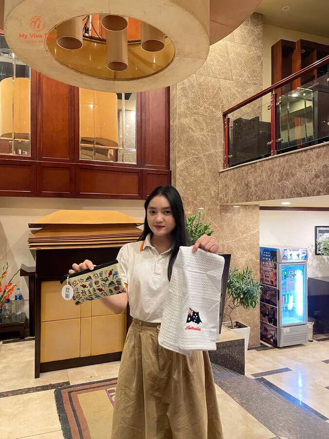 My Viva Tour consultant holding the Australian-flag pouch and scarf gift from Kim Nga in Hanoi