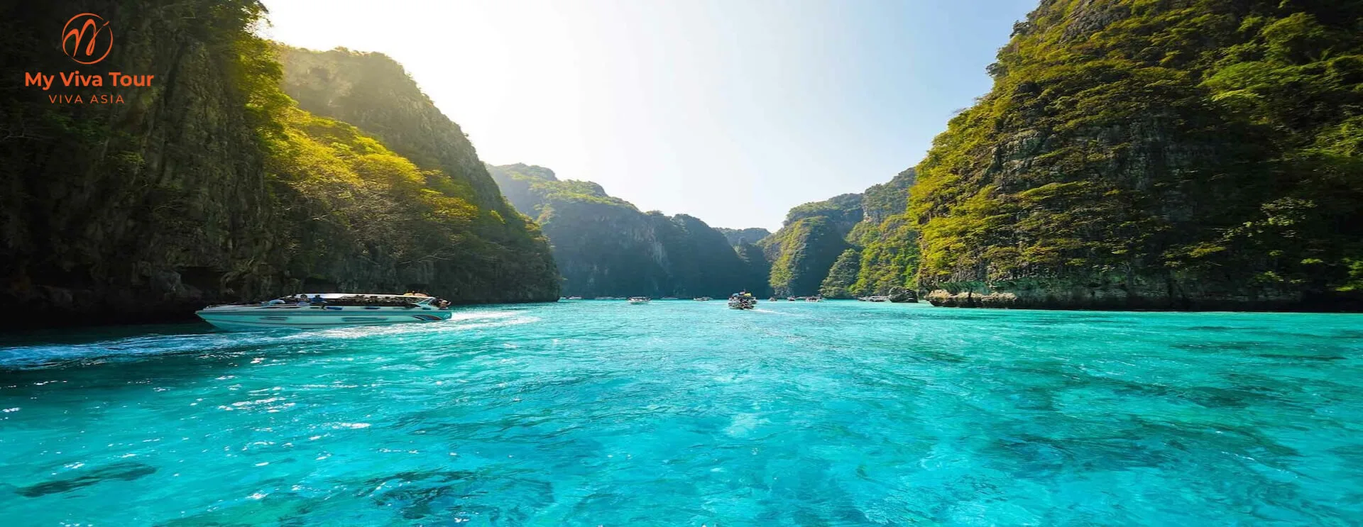 Speedboats in a turquoise lagoon ringed by limestone cliffs on a Krabi island-hopping trip
