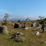 Phonsavan travel guide — dozens of ancient stone jars scattered across the grassy field at Plain of Jars Site 1 near Phonsavan, Laos