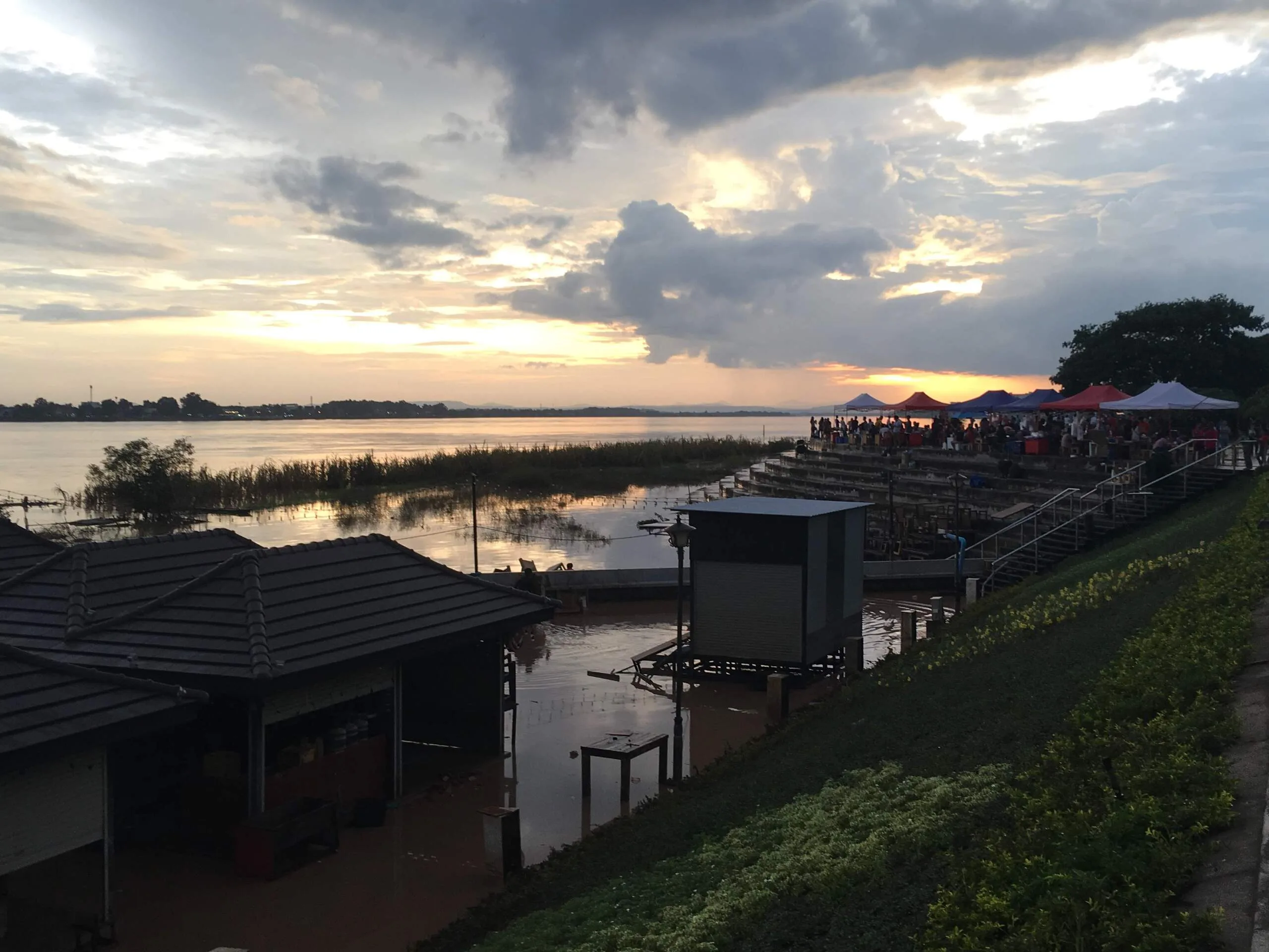 Sunset over the Mekong River with riverside market tents on the Vientiane waterfront