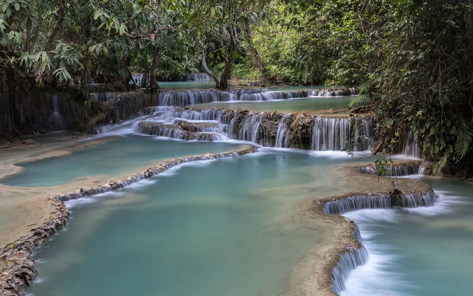 Turquoise tiered pools of Kuang Si Falls in the jungle near Luang Prabang