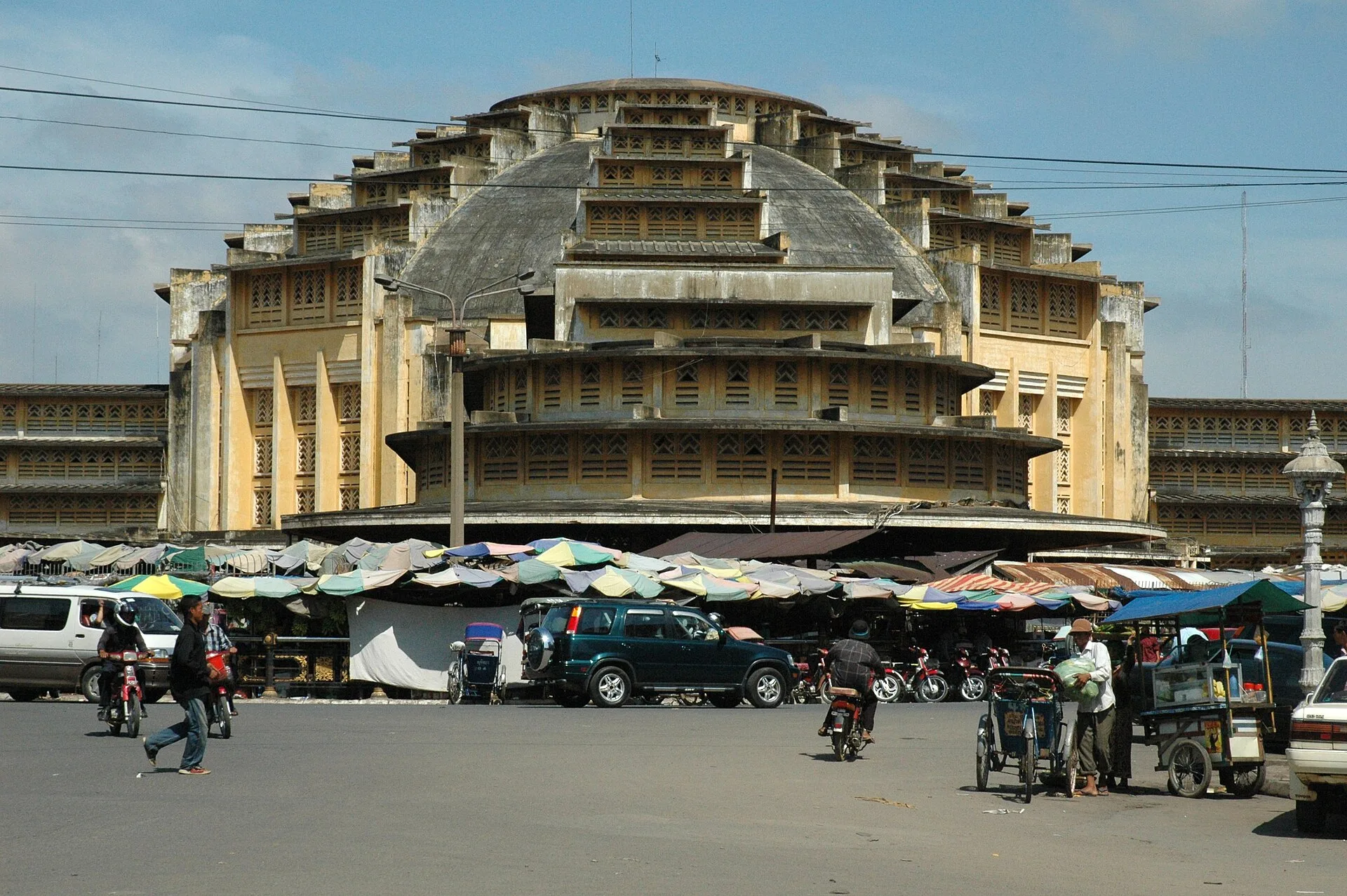 The Art Deco central dome of Phsar Thmei (Central Market) in Phnom Penh with market stalls and tuk-tuks in front