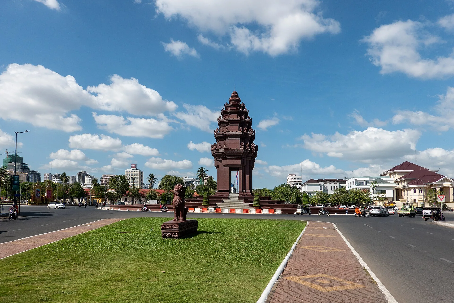 The terracotta lotus-shaped Independence Monument of Phnom Penh on its roundabout under a blue sky