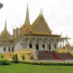 Phnom Penh travel guide: the golden-roofed Throne Hall and spire of the Royal Palace with palace guards on the red-carpeted steps
