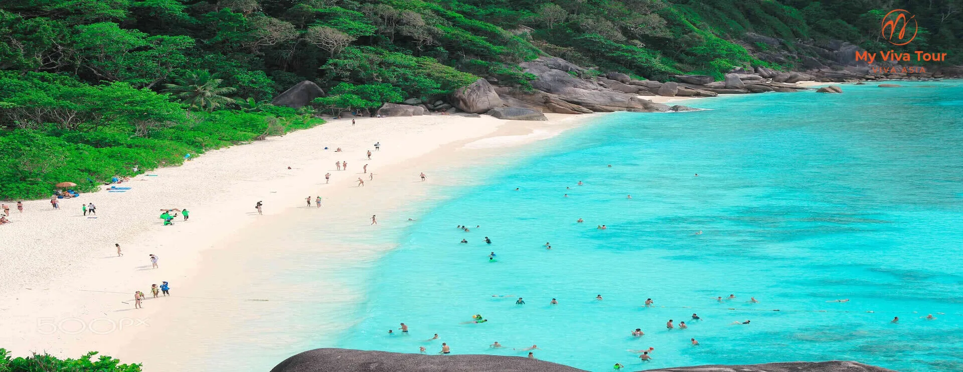 White-sand beach with granite boulders, jungle and clear turquoise water on the Andaman coast near Phuket, Thailand