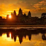 Angkor Wat temple silhouetted at sunrise with its towers reflected in the moat, Siem Reap, Cambodia