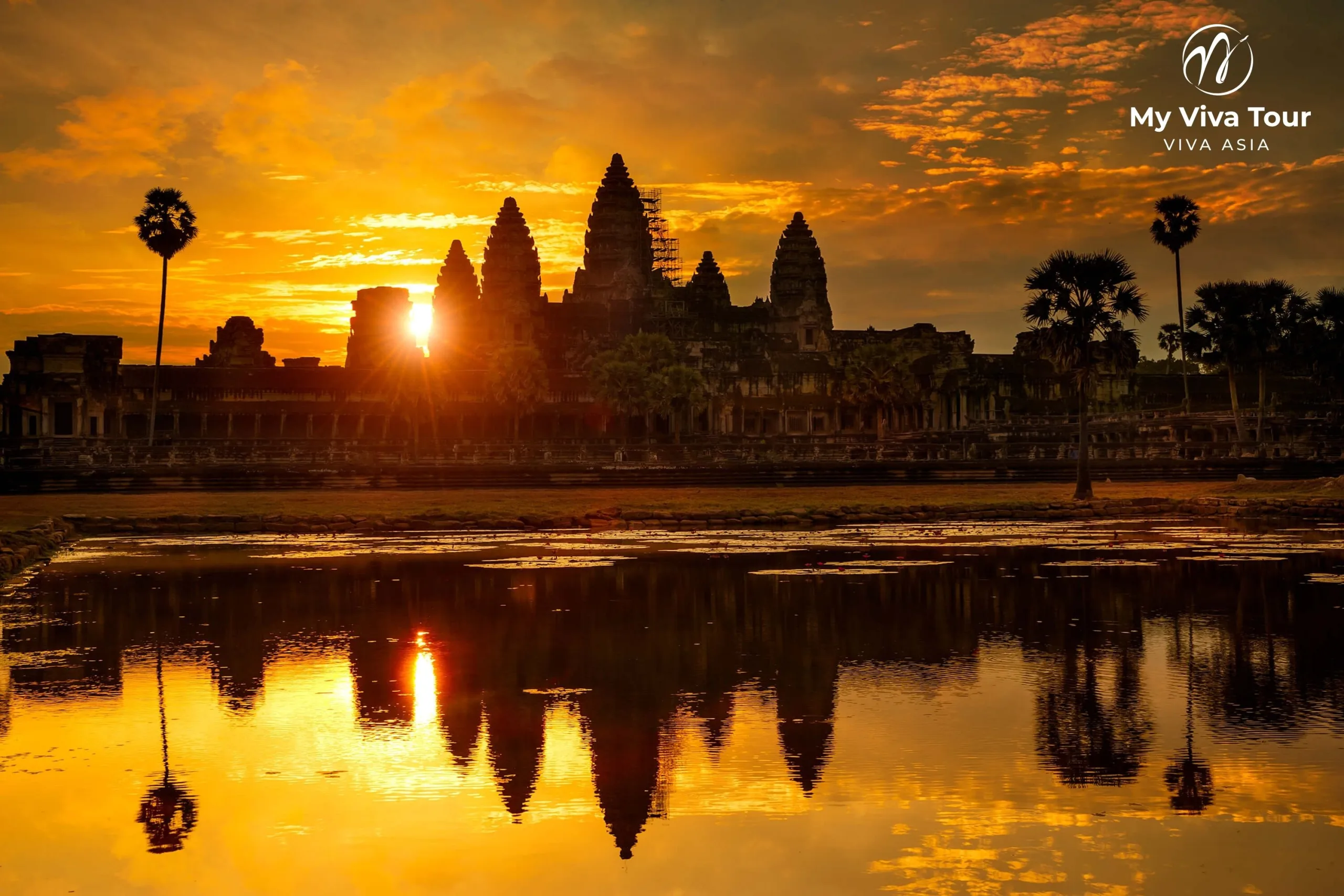 Angkor Wat temple silhouetted at sunrise with its towers reflected in the moat, Siem Reap, Cambodia