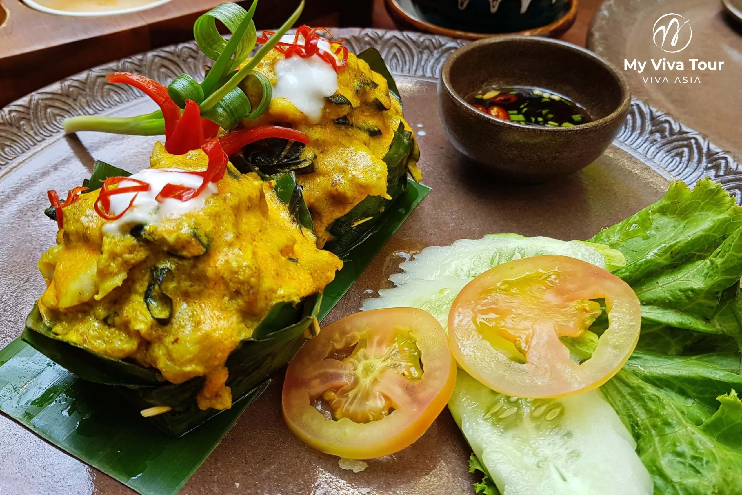 Cambodian fish amok curry steamed in banana-leaf cups with chilli, coconut cream and fresh vegetables, a classic Khmer dish in Siem Reap