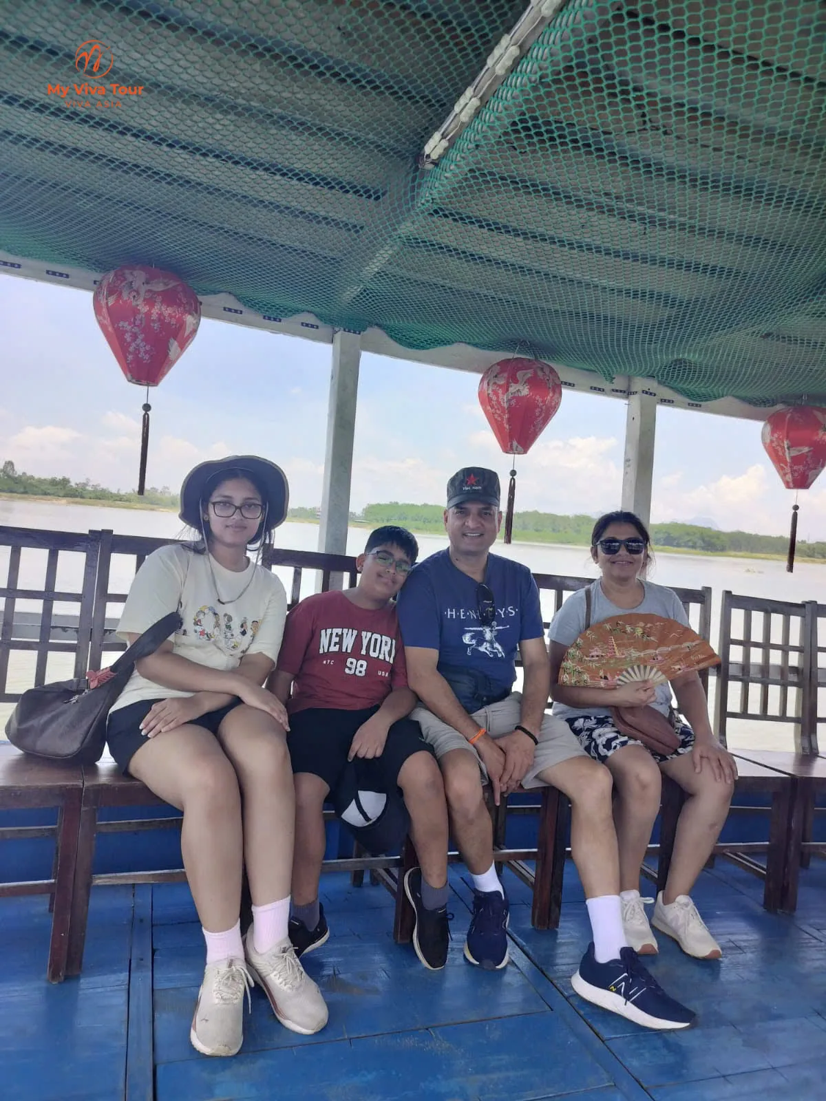 Vikram's family on a lantern-hung wooden river boat travelling down the Thu Bon River back to Hoi An