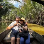 Edward's Vietnam trip — the couple making a heart shape on a Mekong Delta boat