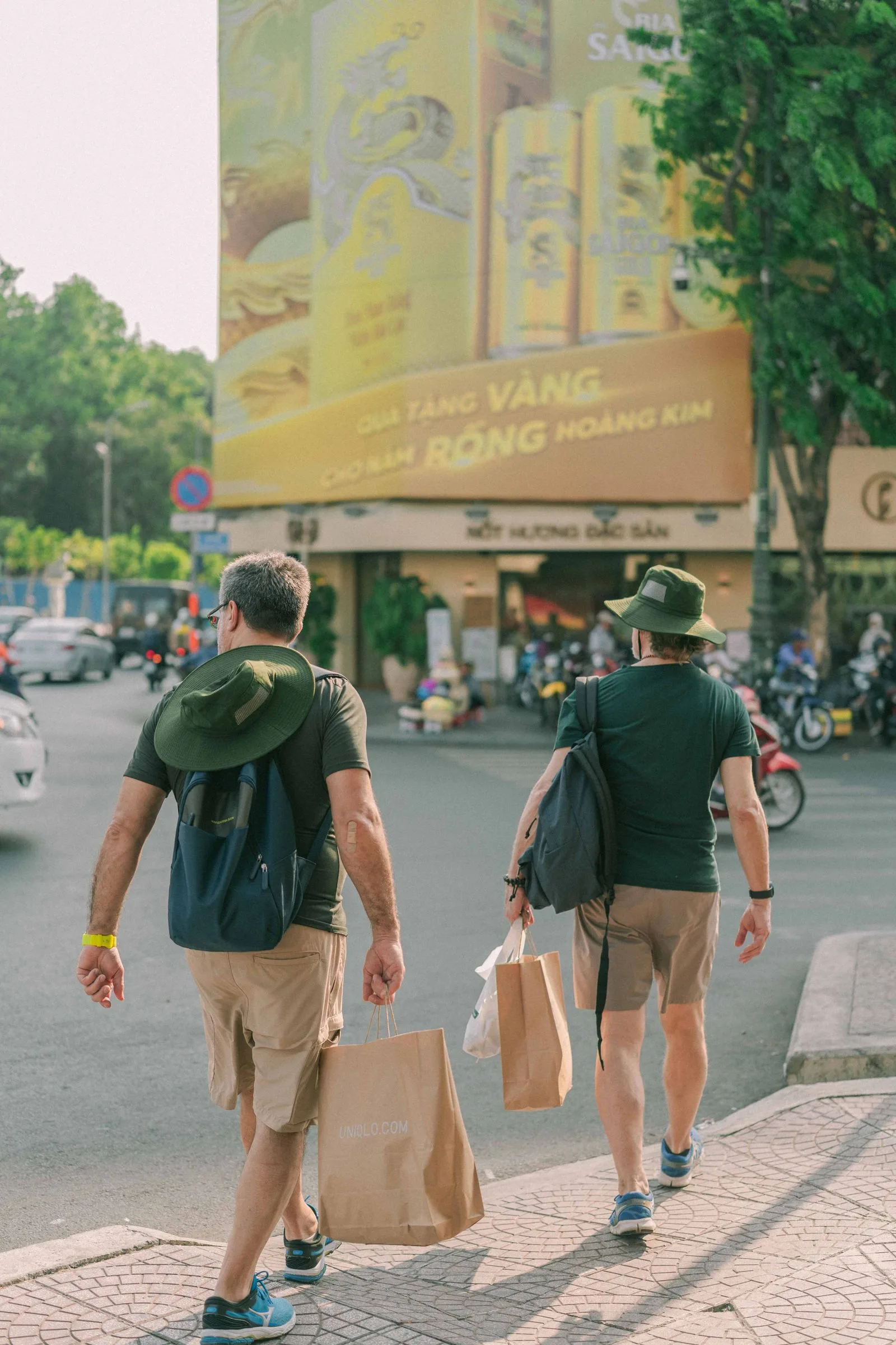 Two travellers walking together down a Ho Chi Minh City street, Vietnam