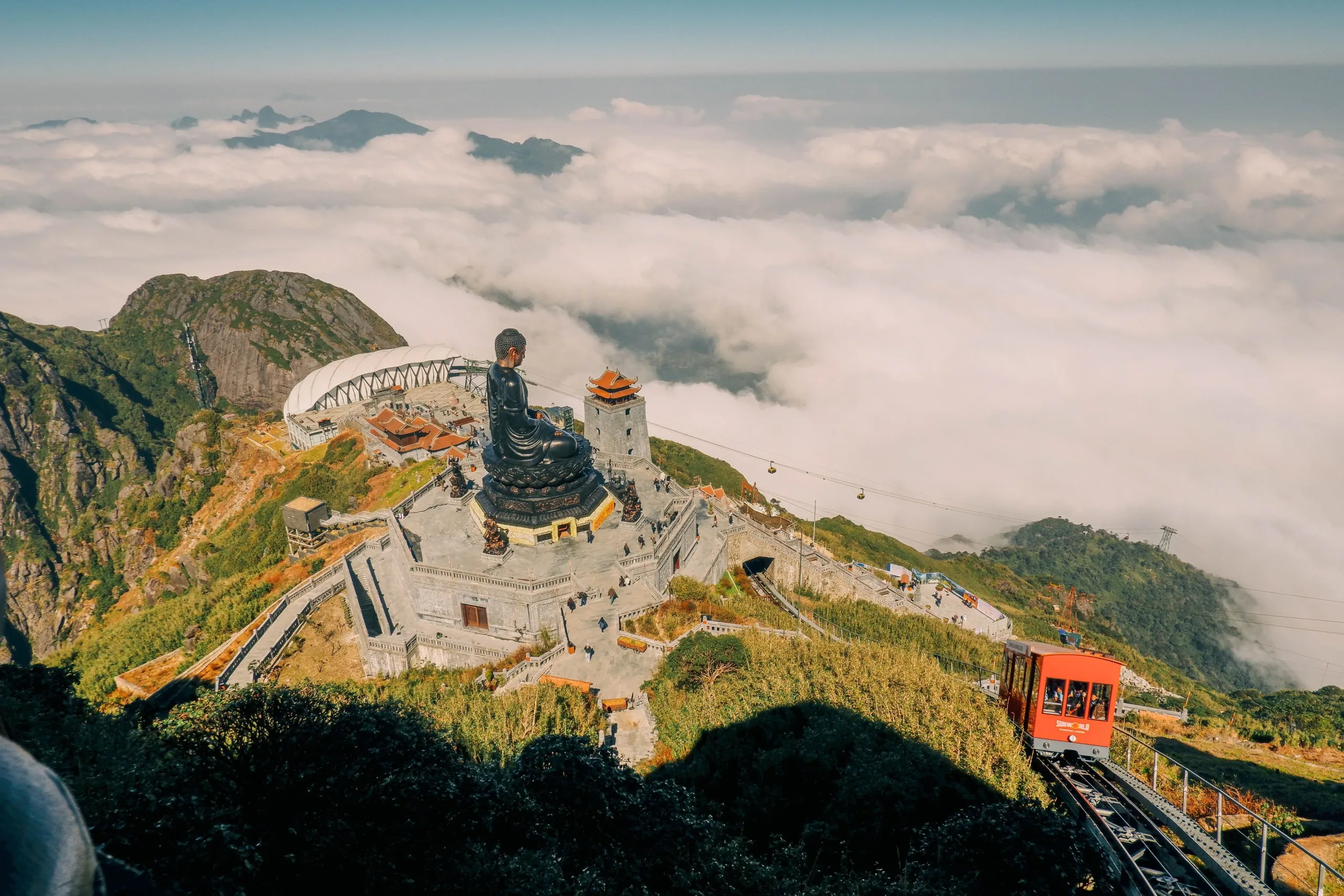 Fansipan summit in the Sapa travel guide — Buddha statue and Fansipan Legend cable car above the clouds