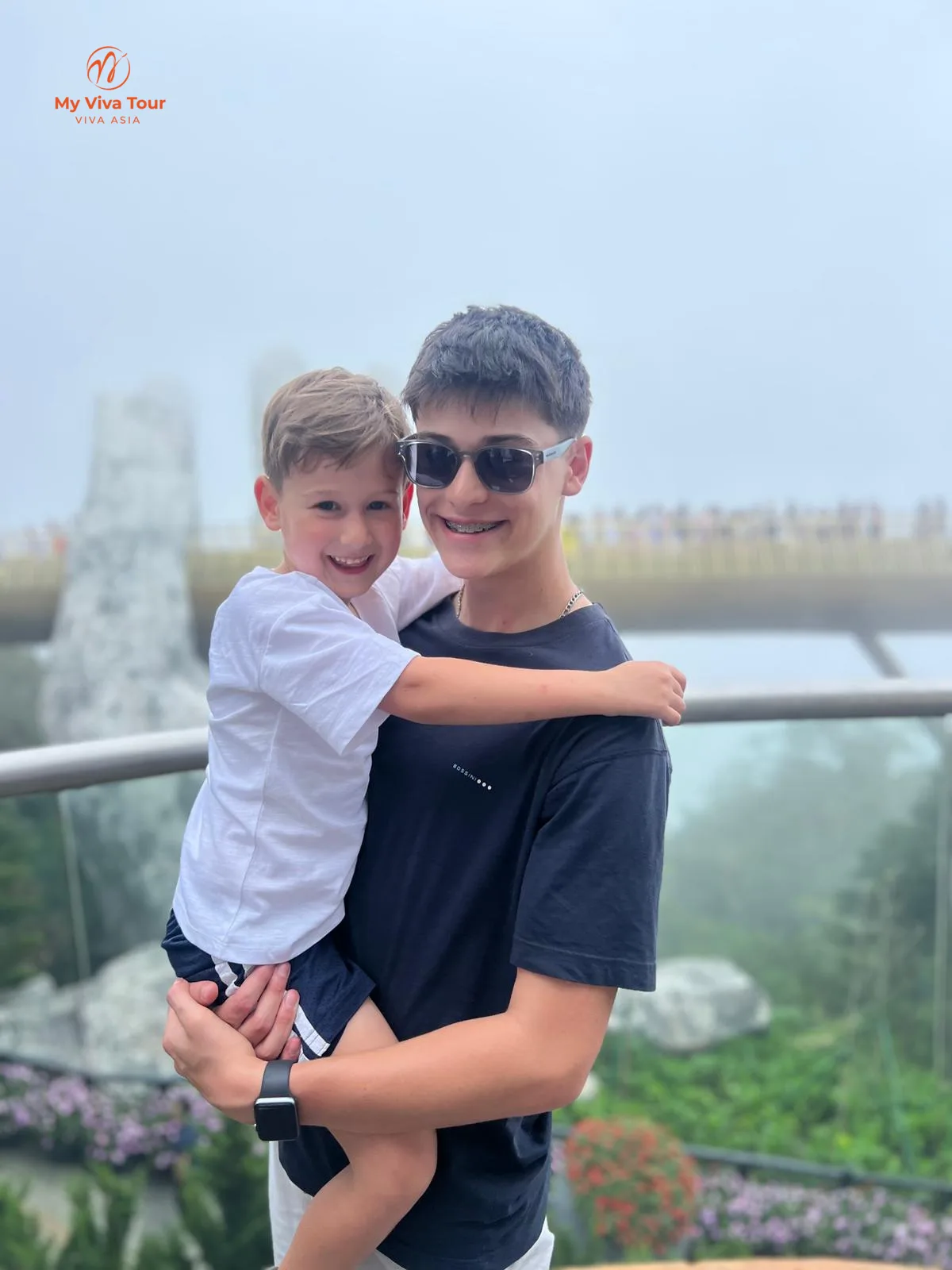 Two brothers hugging on the Golden Bridge at Ba Na Hills, Da Nang, Vietnam