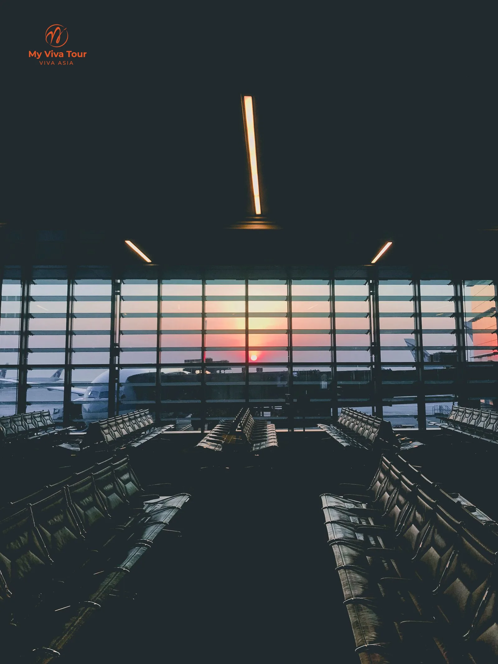 Airport departure lounge at dusk with a wide-body aircraft parked at the gate