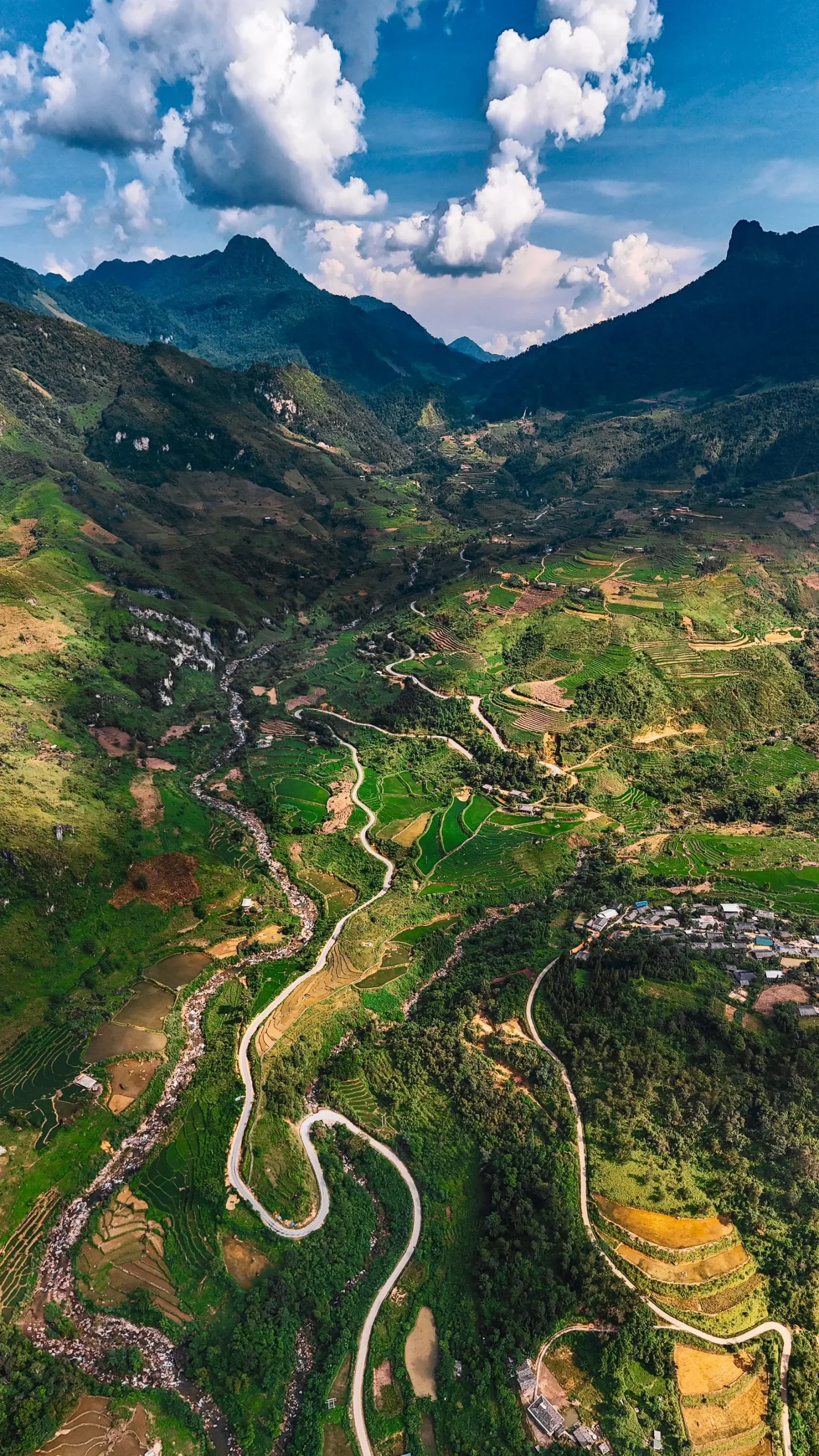 Winding Ha Giang Loop road through a green terraced valley in far-north Vietnam