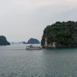 Boat cruising past limestone karsts on Ha Long Bay, Vietnam