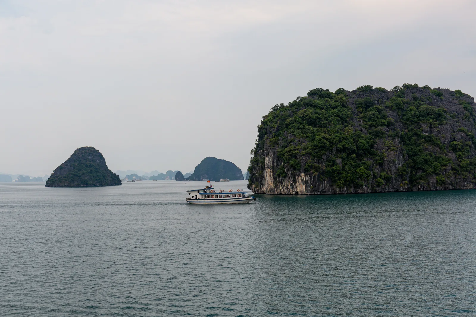 Boat cruising past limestone karsts on Ha Long Bay, Vietnam