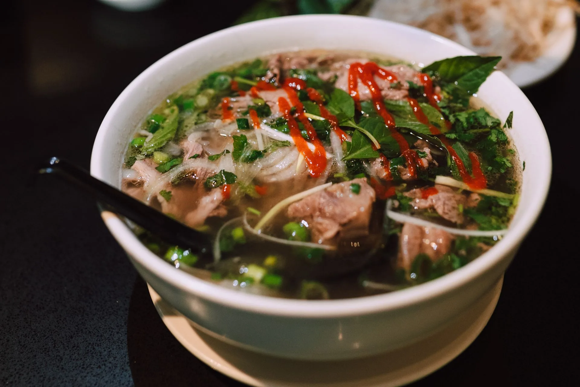 Bowl of Hanoi-style beef pho noodle soup with fresh herbs