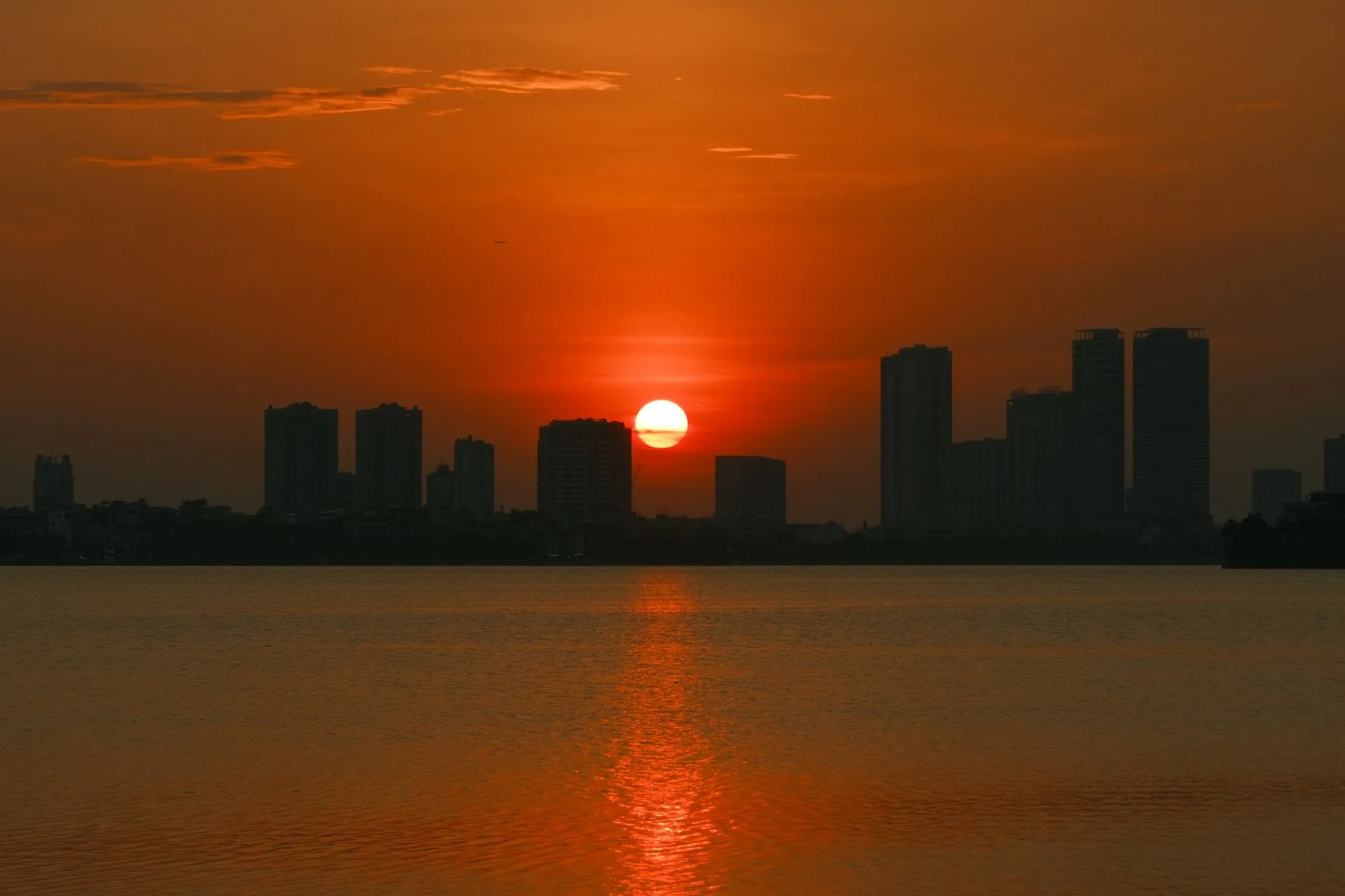 Sunset over the Hanoi skyline reflected in the water