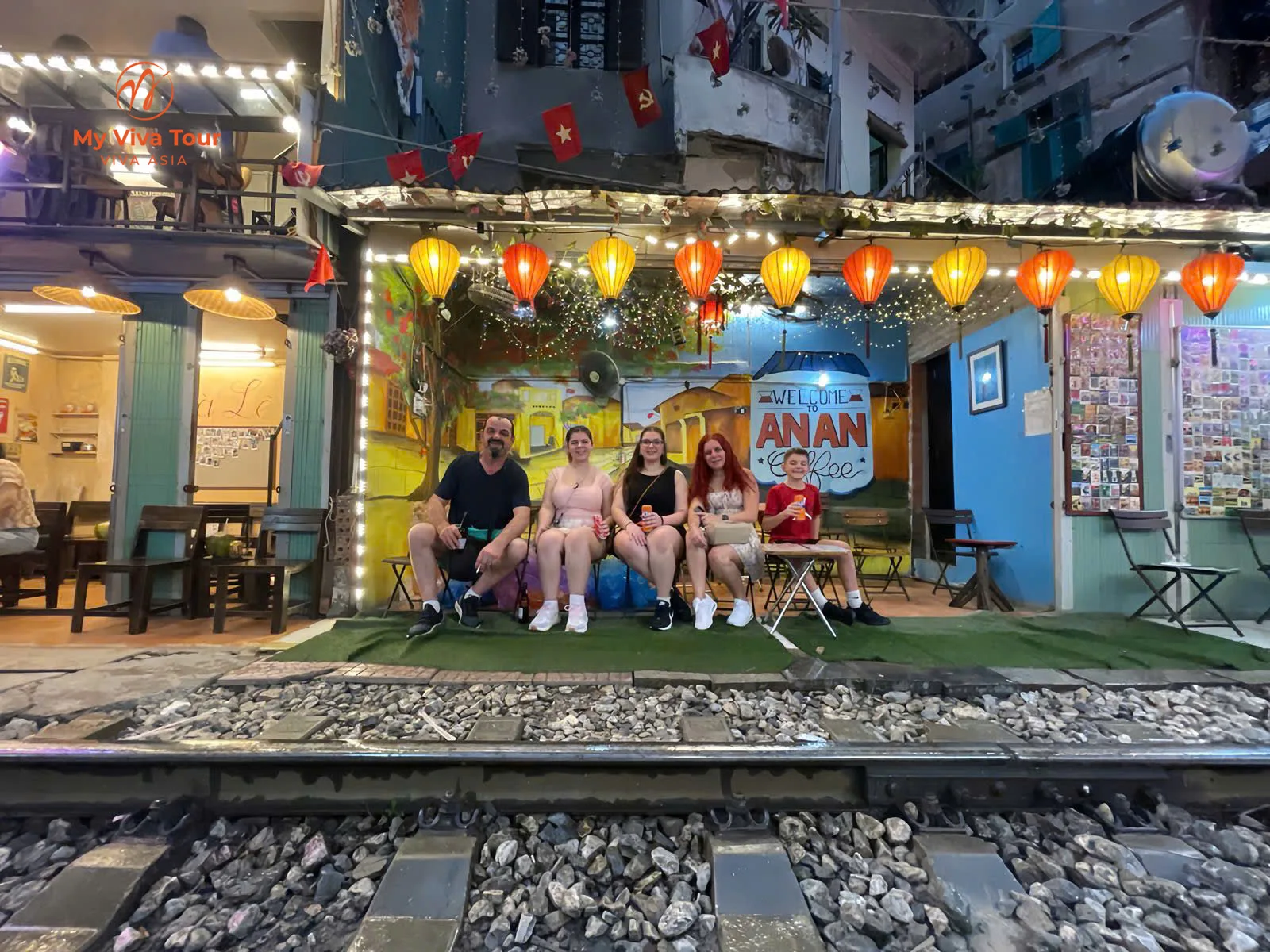 Family relaxing at a lantern-lit cafe on Hanoi's Train Street
