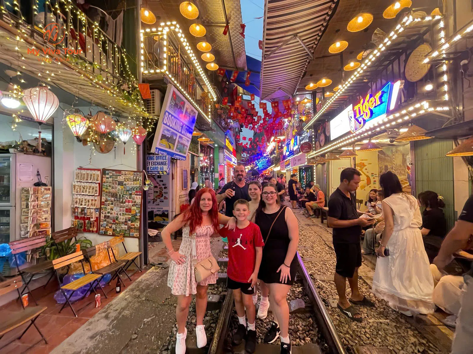 Family posing on the tracks of Hanoi's Train Street at night