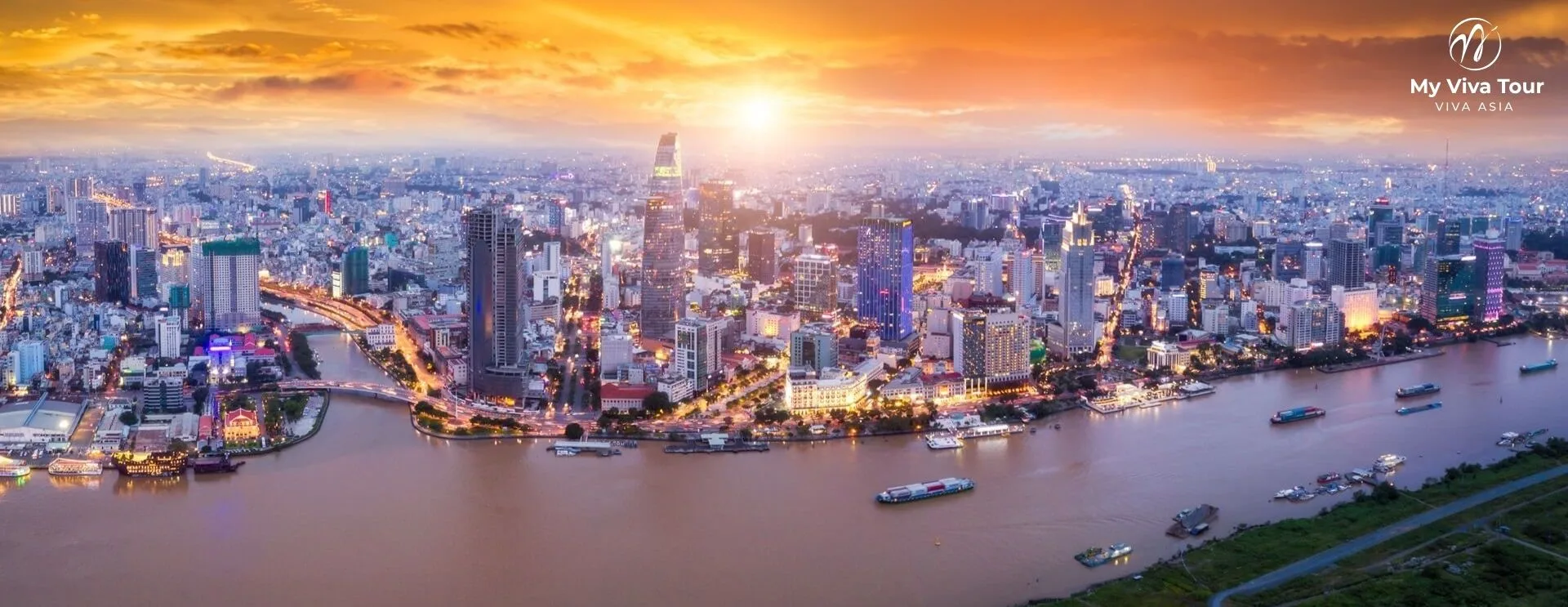 Aerial sunset view of the Ho Chi Minh City skyline and Bitexco tower along the Saigon River, Vietnam