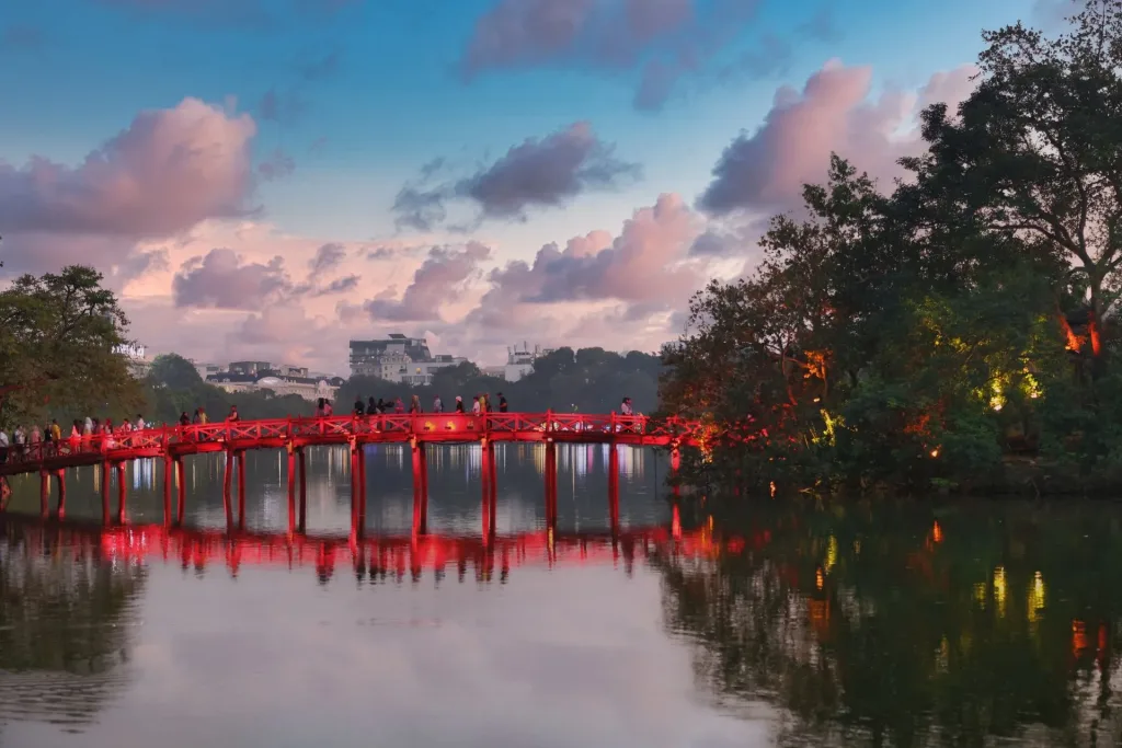Ha Noi travel guide highlight: the red Huc Bridge crossing Hoan Kiem Lake at dusk