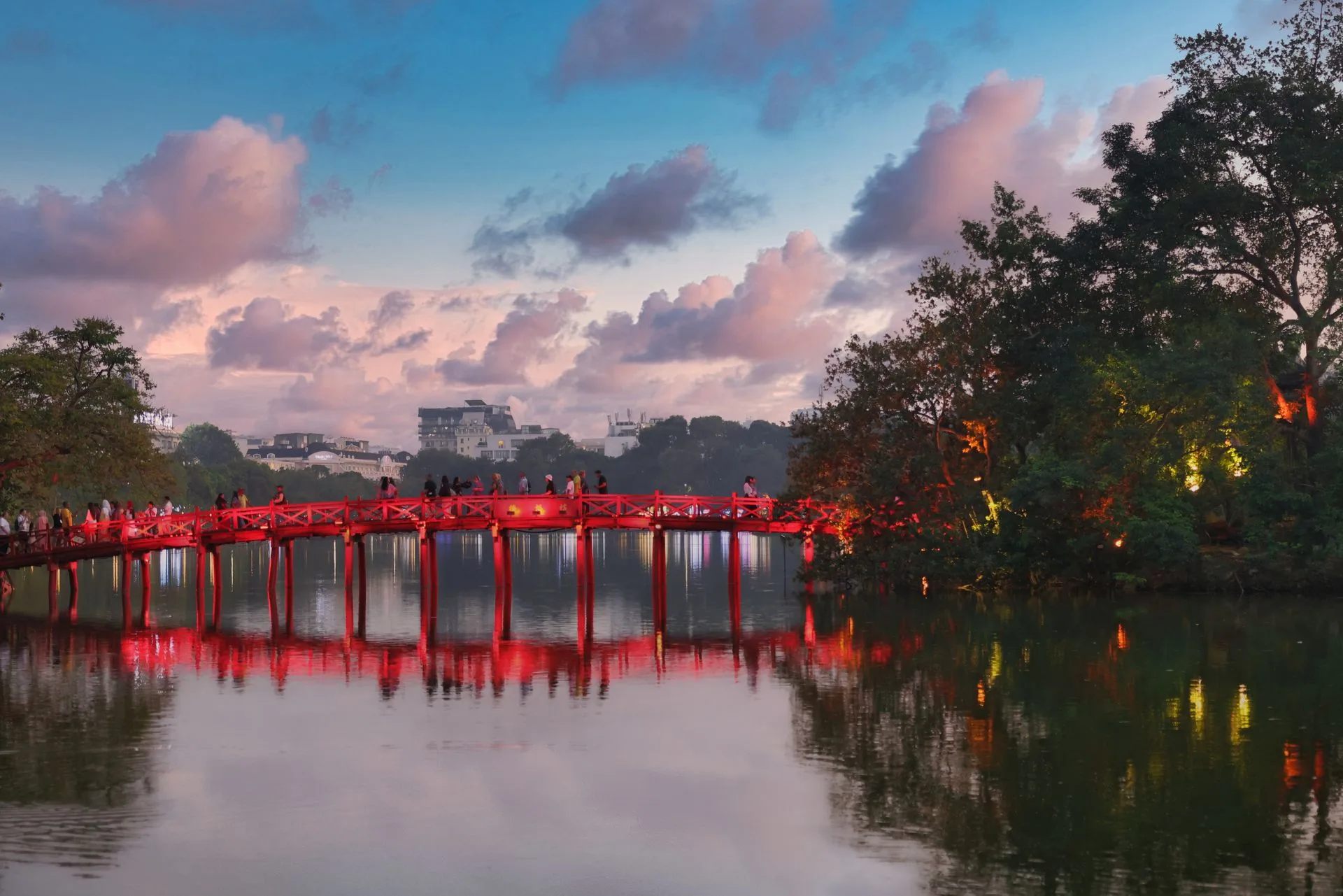 Ha Noi travel guide highlight: the red Huc Bridge crossing Hoan Kiem Lake at dusk