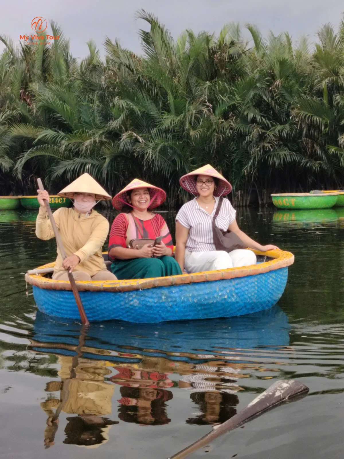 Two of Vikram's family in a round basket boat among the water palms at Cam Thanh coconut forest near Hoi An