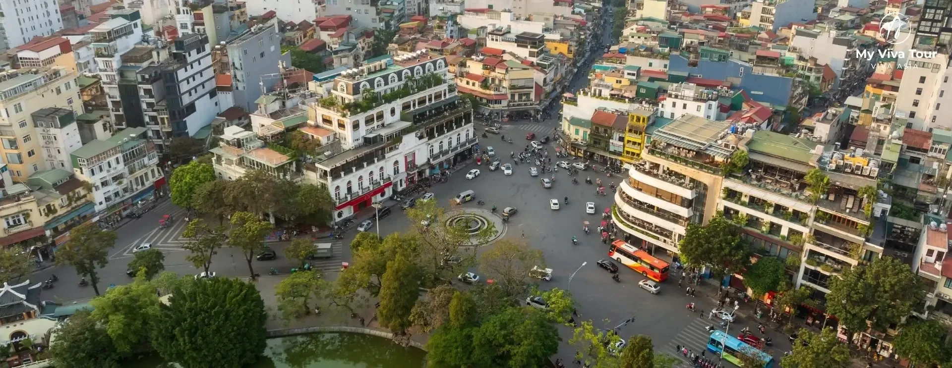 Motorbikes and cars flowing calmly around a Hanoi Old Quarter roundabout