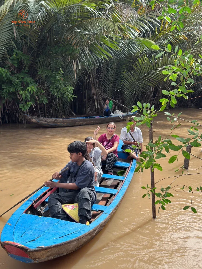 Jerome's family on a small boat gliding through the Mekong Delta's palm-lined canals