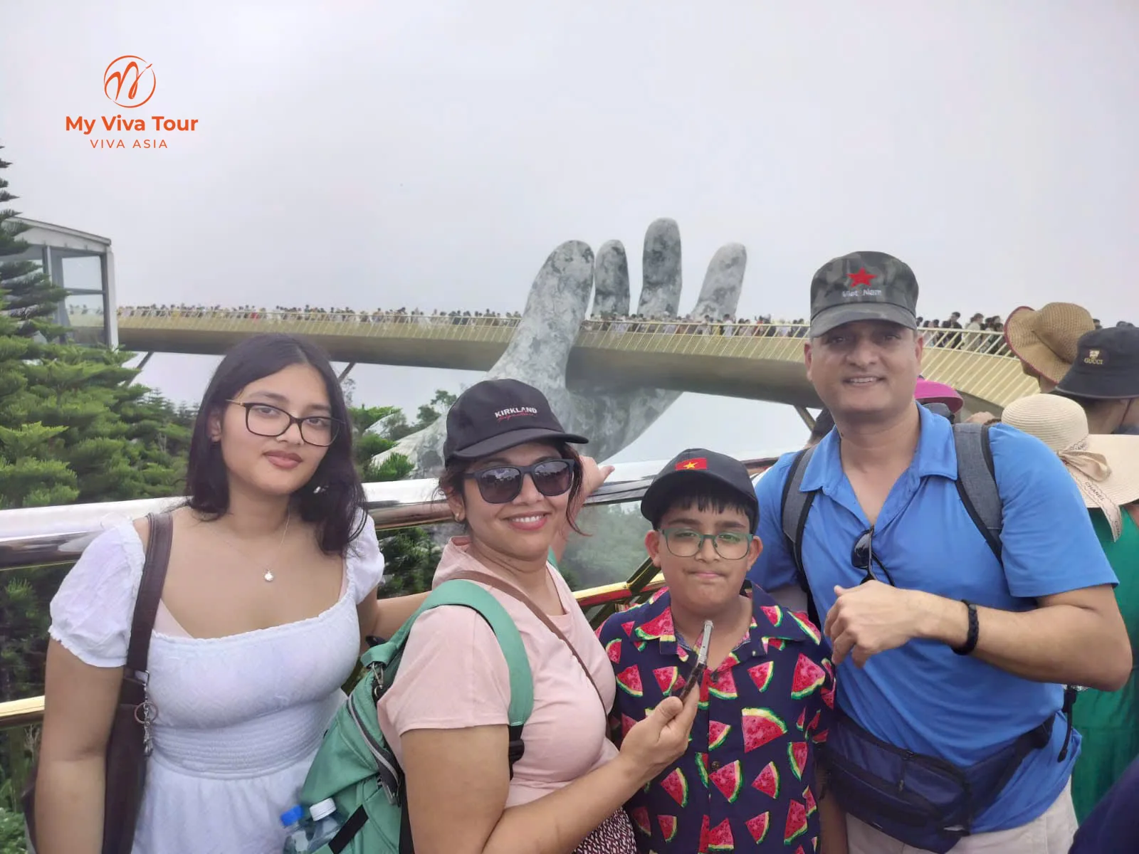 Vikram's family in front of the Golden Bridge's giant stone hands at Ba Na Hills, Da Nang, on a misty day
