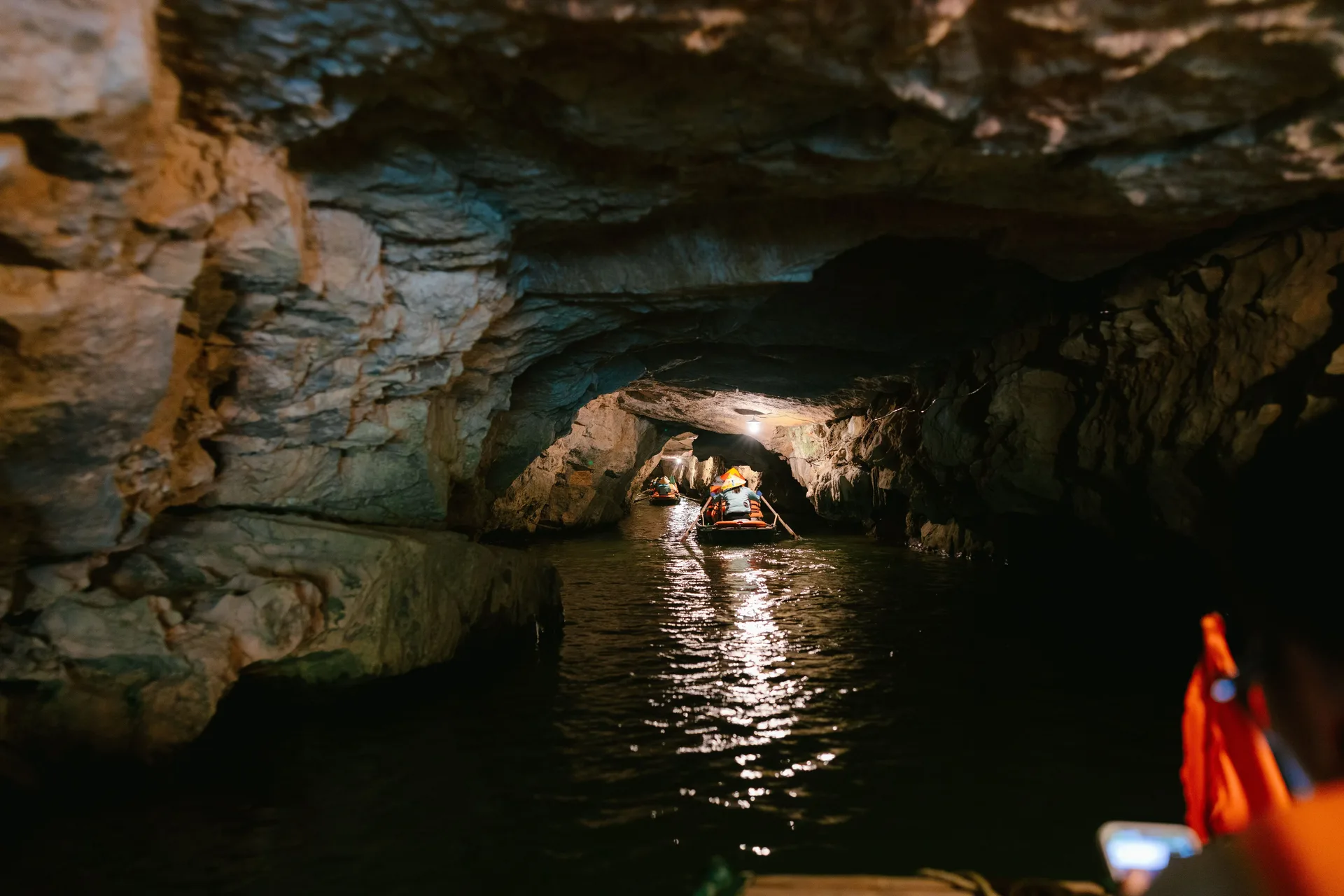 Traditional boat gliding through a limestone cave on a Ninh Binh boat trip