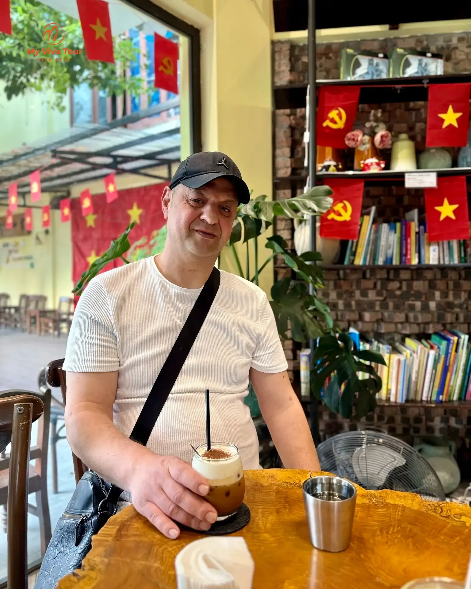 Ovidiu enjoying an iced Vietnamese coffee at a Hanoi cafe decorated with Independence Day flags