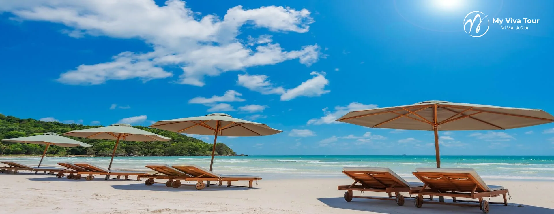 Wooden sun loungers and umbrellas on the white sand of Bai Sao Beach beside turquoise sea on Phu Quoc island, Vietnam