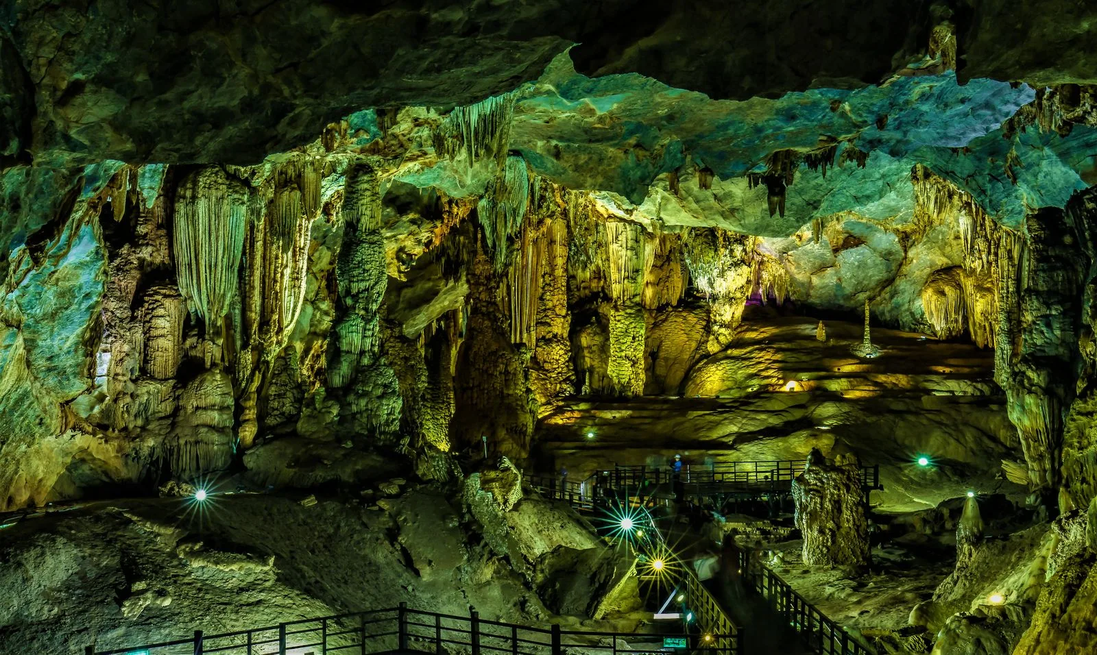 Illuminated stalactites and stalagmites lining the boardwalk inside a Phong Nha show cave in Quang Binh