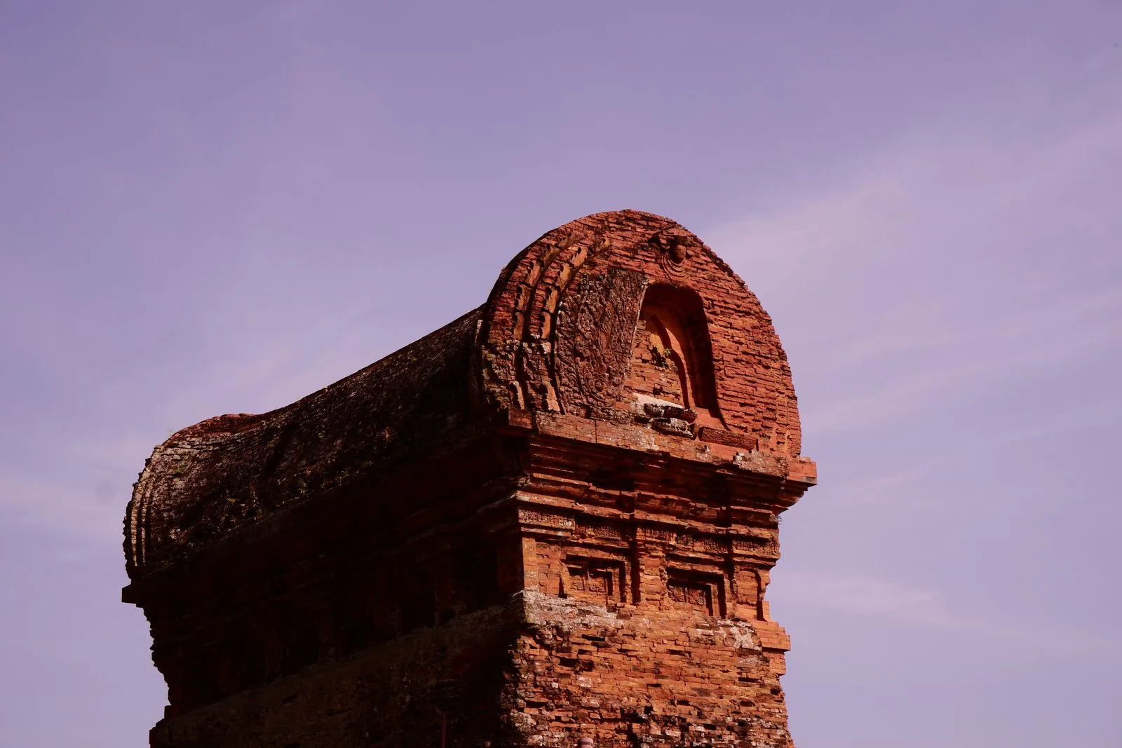 Red-brick Banh It Cham tower near Quy Nhon with carved arch and evening sky