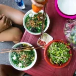 Bowls of fresh Vietnamese street food with herbs and chopsticks, Vietnam
