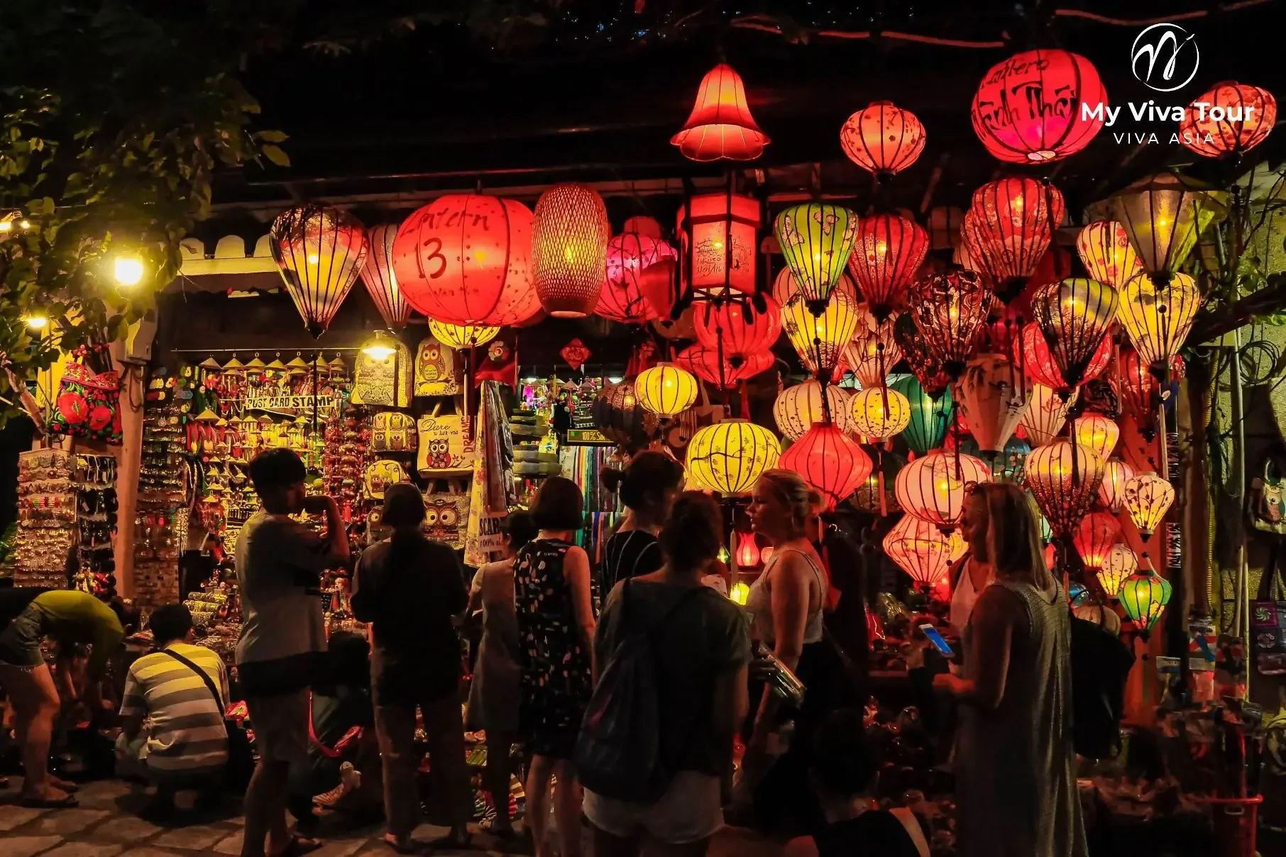 Glowing silk lanterns light up a night market street in Hoi An old town, Vietnam