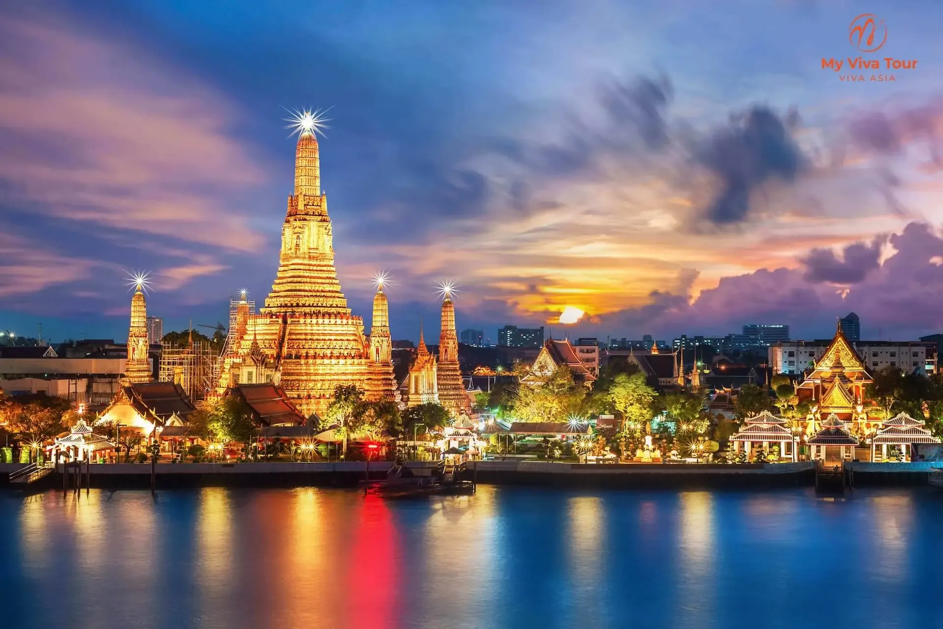 Wat Arun temple illuminated at twilight above the Chao Phraya River in Bangkok, Thailand