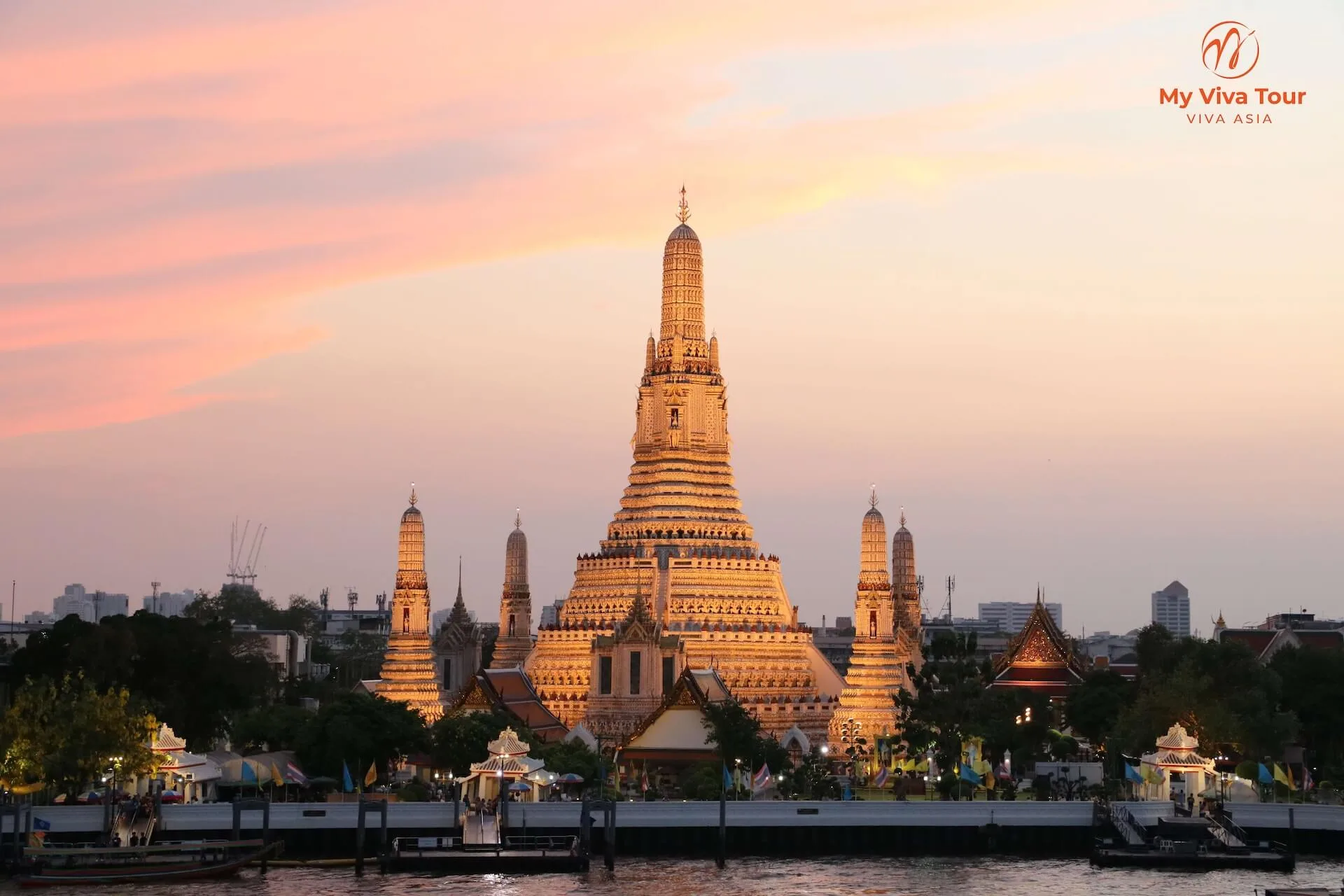 Wat Arun temple lit by the setting sun on the Chao Phraya River in Bangkok