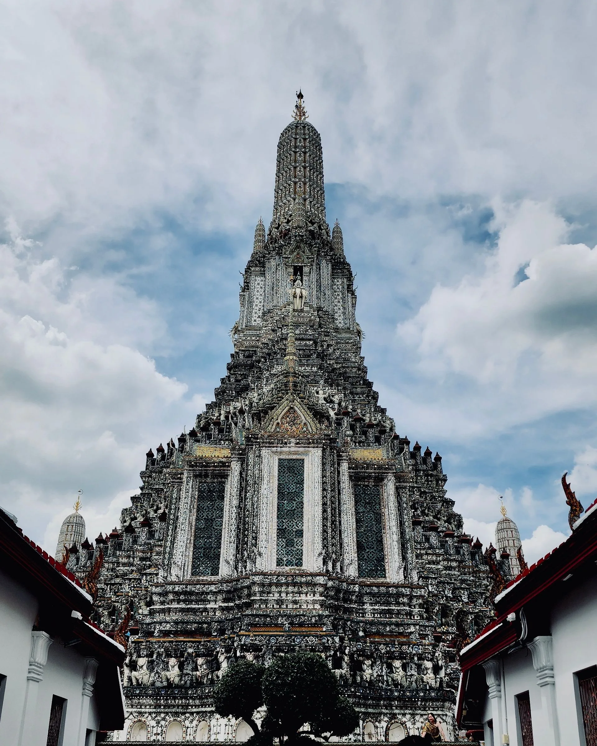 Ornate spire of Wat Arun temple against a blue sky in Bangkok, Thailand