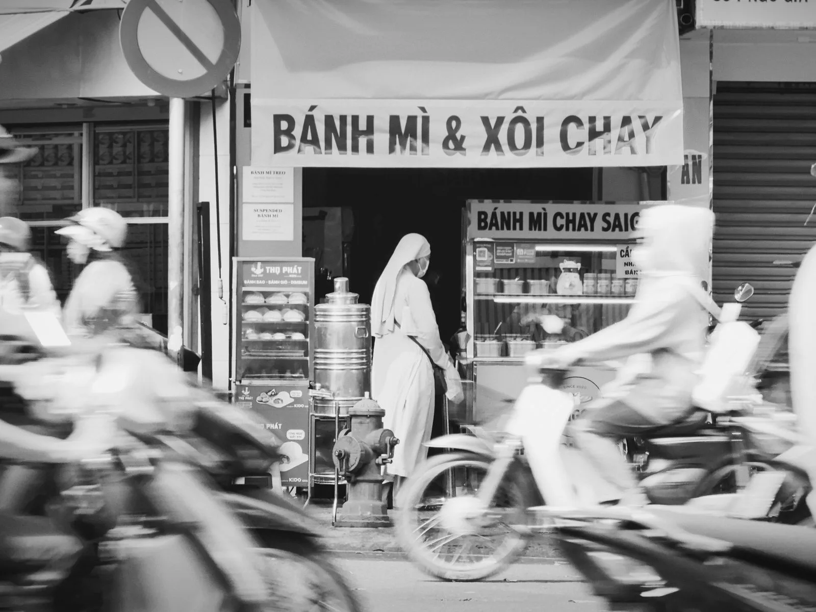 Ho Chi Minh City travel guide: a banh mi street stall in Saigon with motorbikes passing
