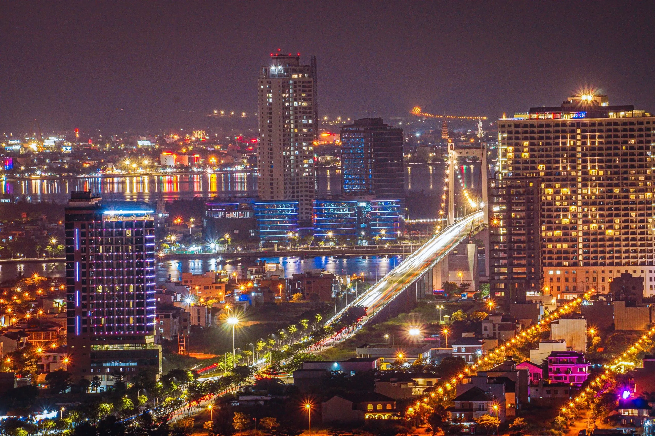 Da Nang’s Han River bridges lit up at night with light-trail traffic