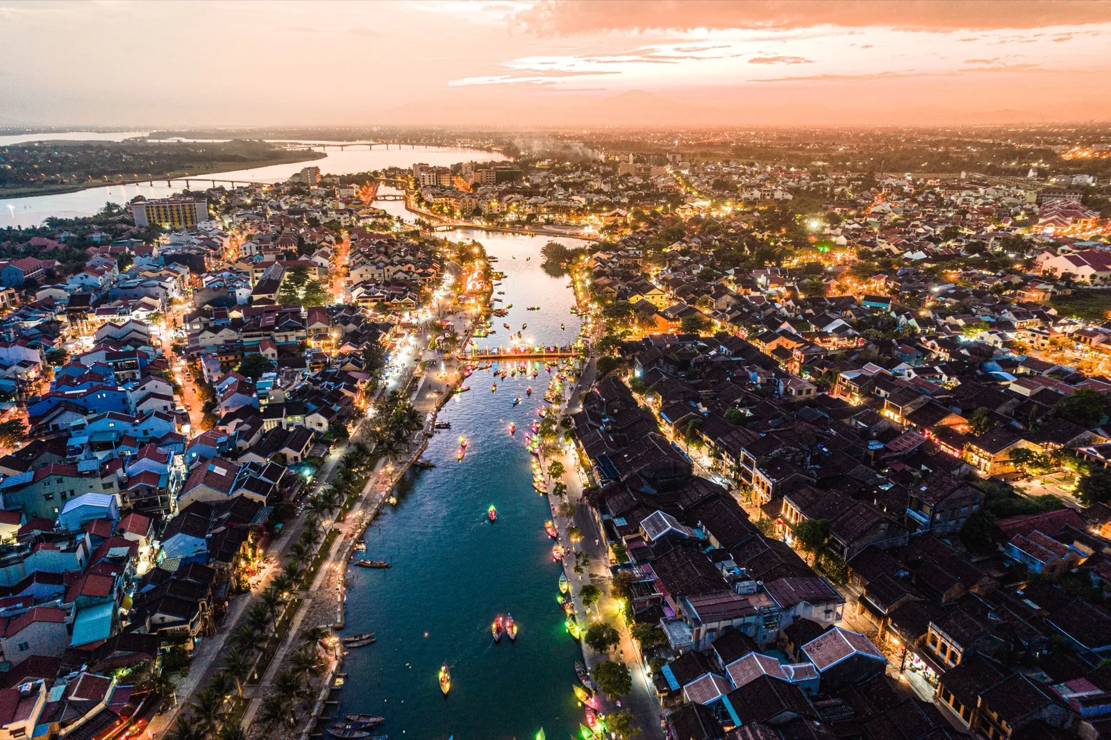 Aerial view of Hoi An Old Town and the Thu Bon River lit up at dusk